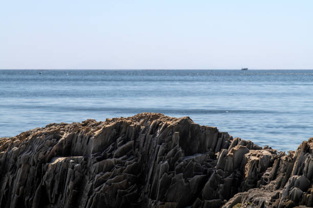 istock rock against the calm sea 2159005396