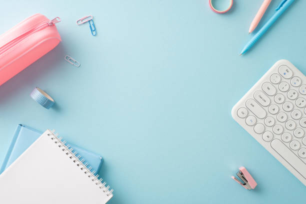 istock A neatly organized desk setup featuring school and office essentials such as notebooks, pens, and a keyboard, perfectly arranged on a light blue background 2159006877