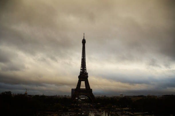 istock eiffel tower etched against cloudy sky at dusk 2159008017