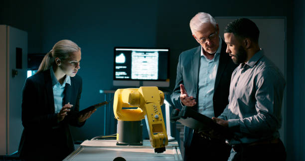istock Teamwork, robotics and people with tablet, industry and futuristic with brainstorming, network or machine learning. Group, coding for robot arm and technology, collaboration or productivity with idea 2159009408