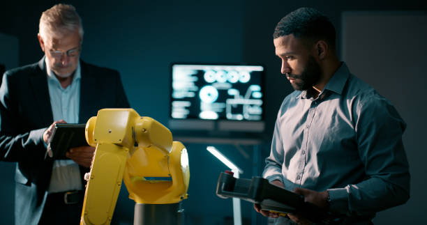 istock Men, robotics arm and tablet with engineering, science and futuristic with connection, collaboration and machine learning. Group, coding or employees with industrial tech or programming with research 2159009443