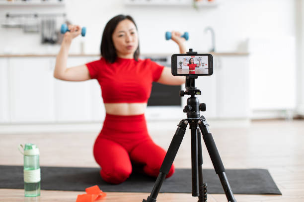 istock Woman recording home workout video with dumbbells 2159010225