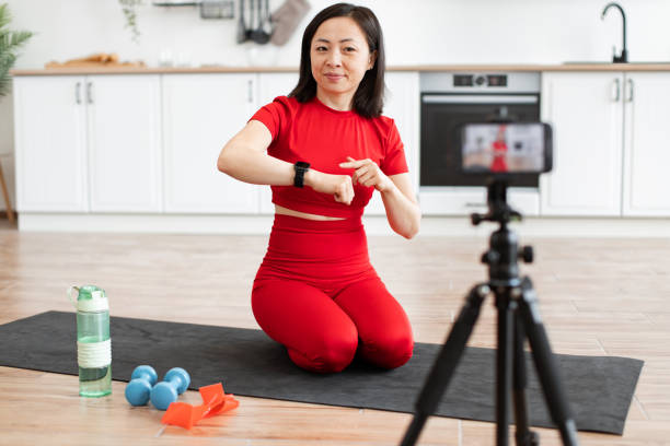 istock Sporty woman in red talks about smart watch during workout 2159010256