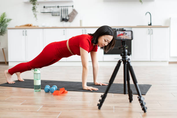 istock Woman doing home workout and recording fitness video tutorial 2159010262