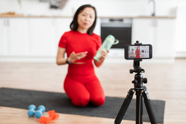 istock Woman recording fitness tutorial at home with smartphone 2159010271