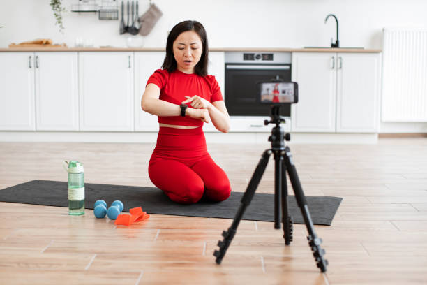 istock Sporty woman using smart watch during home workout video 2159010290