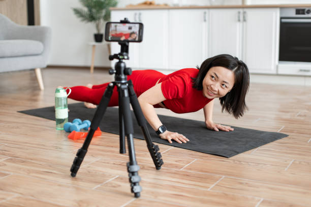 istock Woman doing push-ups at home during online workout session 2159010295