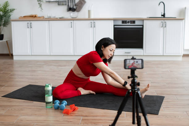 istock Woman recording stretching routine in modern kitchen 2159010328