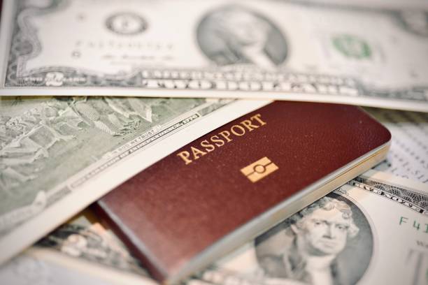 istock passport with dollar bills placed above and below it, viewed from a macro perspective view 2159010772