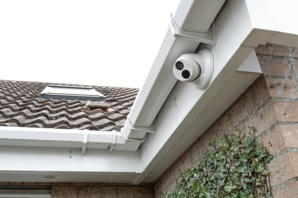 Newly installed dome CCTV night and day camera fitted to the eaves of a modern house. stock photo