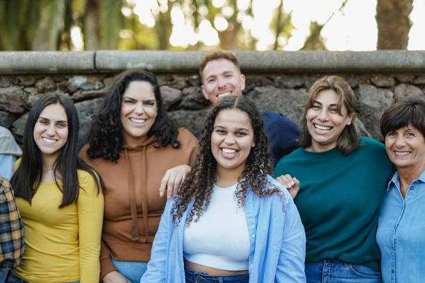 istock Group of multi generational people having fun together outdoor while smiling on camera - Multiracial friends enjoy day at city park - Community concept 2159017495
