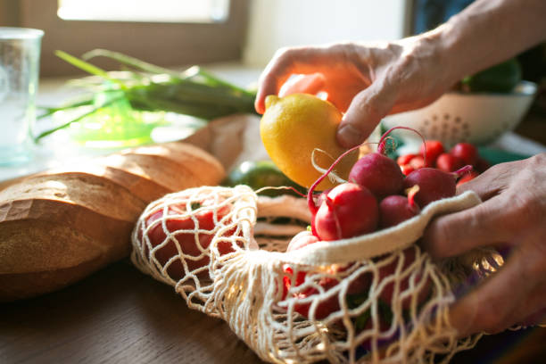 istock Senior man unpacking groceries at kitchen, reusable shopping bag with fruit and vegetables, environment conservation and sustainability concept 2159018377