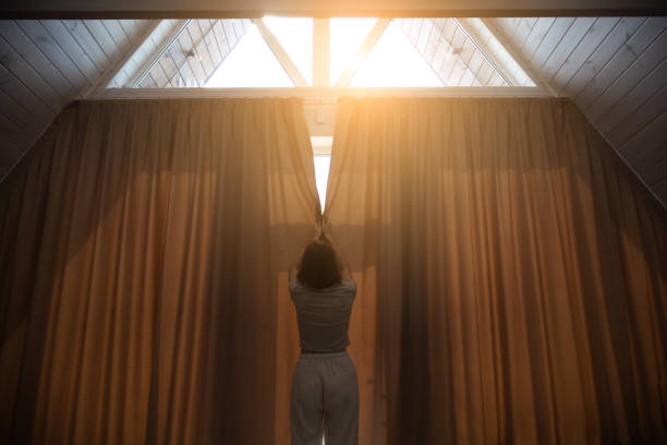 istock Woman is closing big curtains in modern house. 2159020502