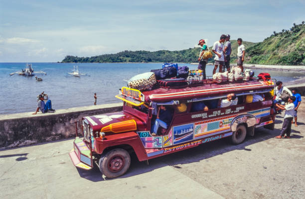 Colorful jeepney and tricycle transporting people along a busy street in Calapan City, Philippines, showcasing typical local public transport.