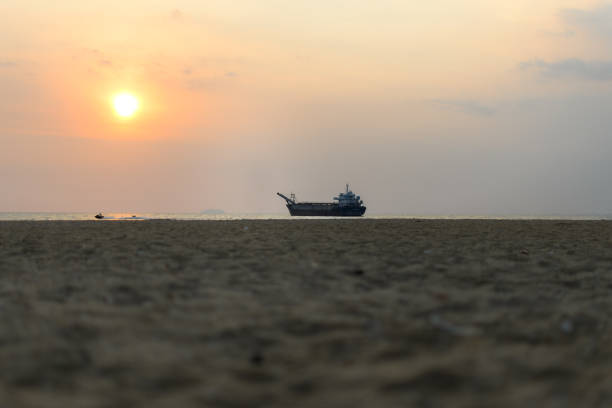 Standing alone on the beach, watching the ship in the morning light