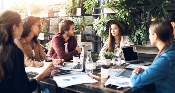istock Creative, workshop and people in cafe for planning, strategy and online startup project development with teamwork. Collaboration, men and women in coffee shop with laptop, paperwork and design ideas 2159023769