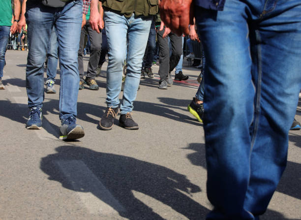 istock men walking on the street in jeans during a workers strike with their faces invisible 2159027803