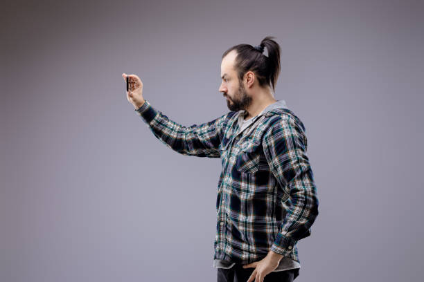 istock Bearded man taking a selfie with smartphone on gray background 2159027905