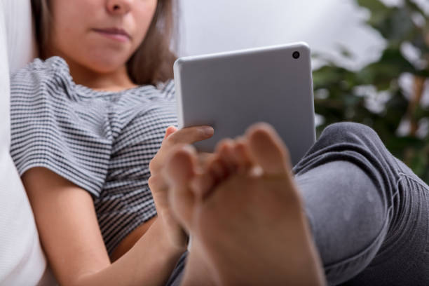 istock Young woman relaxing on couch using digital tablet 2159028153