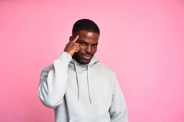 istock Young man pointing at his head showing intelligence on pink background 2159029857