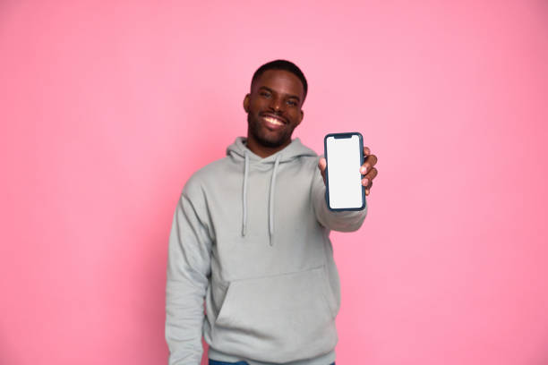 istock Smiling casual man showing smartphone empty screen recommending app 2159030215