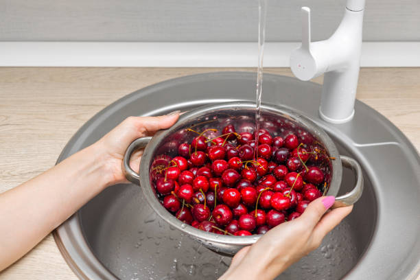 istock housewife washes fresh cherries in a colander in the kitchen. 2159030224