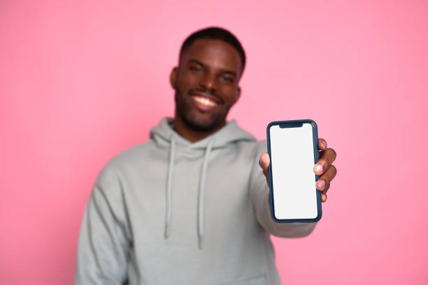 istock Happy man is showing smartphone with blank screen for advertisement 2159030273