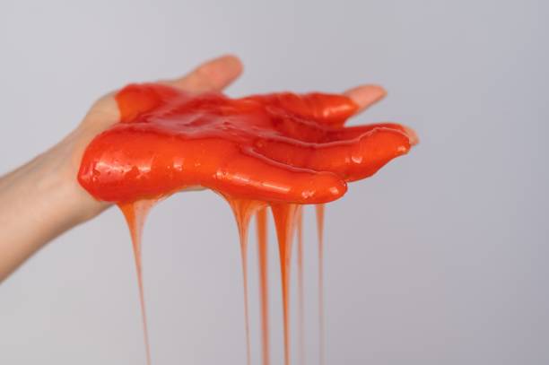 istock Red slime flowing down from a woman's hand on a white background. 2159032041