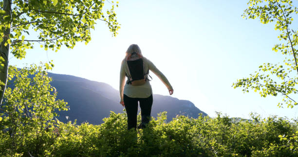 istock Mature female hiker walks in mountain meadow 2159033753