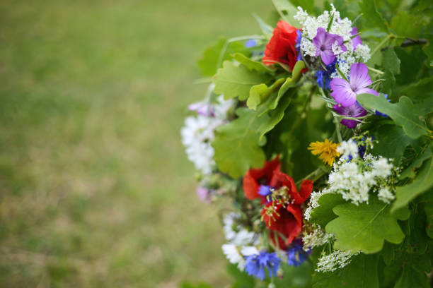 A close-up of a colorful bouquet of wildflowers against a blurred green background.