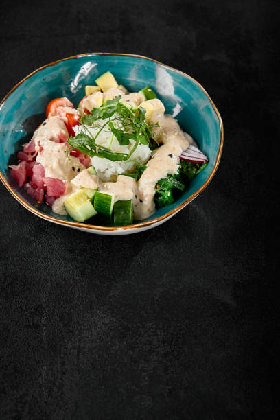 istock Tuna Poke Bowl with Fresh Vegetables on Dark Background 2159038658
