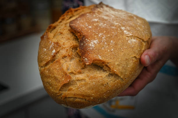 istock Woman with fresh baked sourdough bread in kitchen 1 2159038695