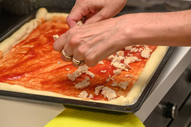 istock woman putting meat on pizza in the kitchen 4 2159040140