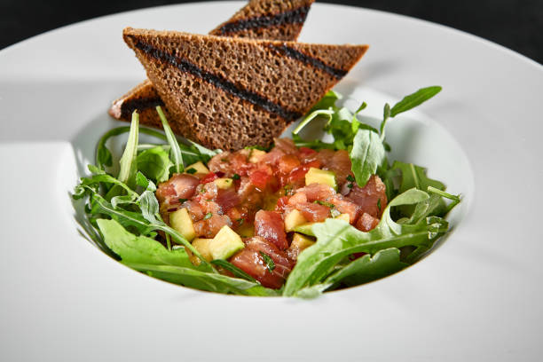 istock Tuna Tartare with Arugula and Toasts on a White Plate 2159040244