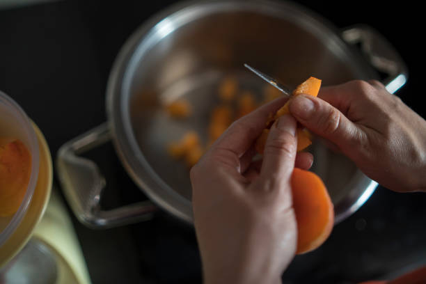 istock Female hands cutting fresh sweet peaches to make peach jam. 2159041204