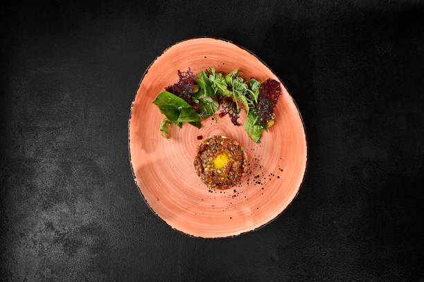 istock Beef Tartare with Quail Egg and Mixed Salad on a Rustic Plate 2159041578