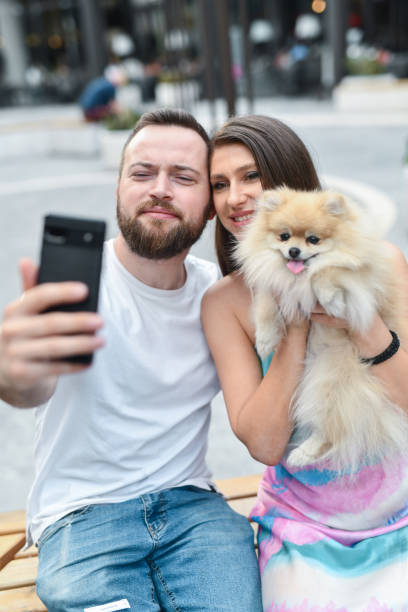 istock Couple Making Funny Faces While Their Pet Pomeranian Is Drooling During Selfie 2159055880