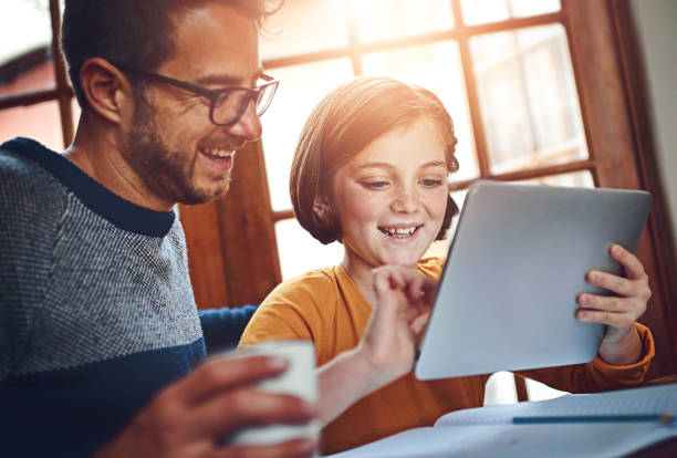 istock Education, tablet and daughter with father in home together for development or distance learning. Family, homework and technology with happy student girl in apartment for growth, homework or study 2159057252