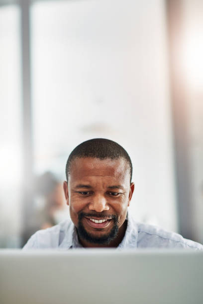 istock African man, computer and space in office for mock up, reading and thinking at media company. Black business person, mature editor and writer by pc, review and smile for story at creative agency 2159060363