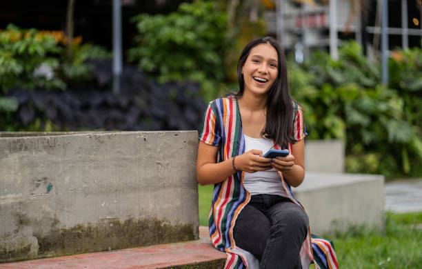istock young latina woman smiling and using her cell phone 2159066164