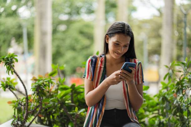istock young woman using her cell phone outdoors 2159066658