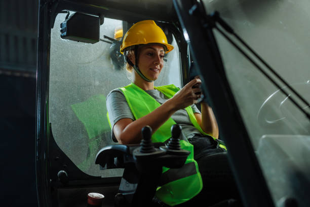 istock Woman smiling and texting while at work in a warehouse 2159067716