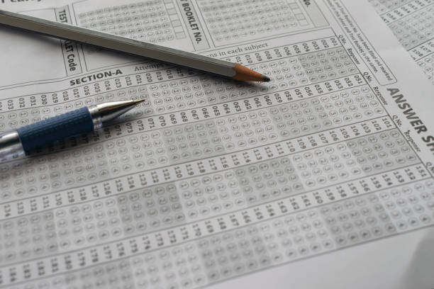istock Blank OMR sheet with pencil pen NEET, JEE, exam centre hall student teacher time important leak paper question marks marking tick scam cheating AIR rank coaching course 2159085425