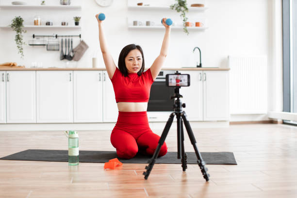 istock Woman exercising with dumbbells during online workout session 2159094152