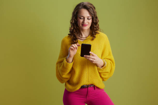 istock happy fit woman using smartphone isolated on green background 2159094409