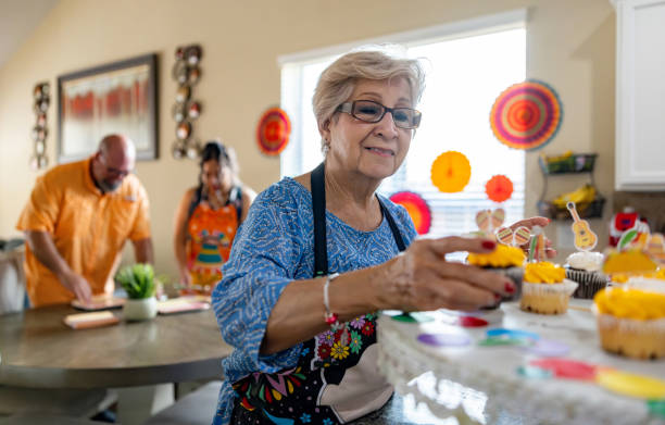 Happy senior woman making cupcakes for a party