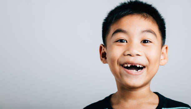 istock Child with missing upper tooth wide smile showing gap. Dental growth and development isolated portrait on white. Tooth loss and care joyful expression. Children show teeth new gap, dentist problems 2159106317