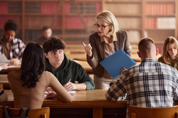 istock Mature professor scolding her students during a class in library. 2159113546