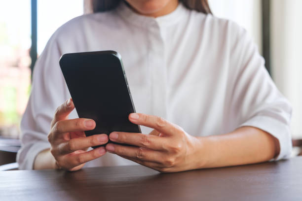 istock Closeup image of a woman holding and using mobile phone 2159115764