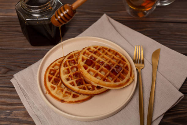 istock A portion of Viennese waffles on a plate, sprinkled with honey 2159116308